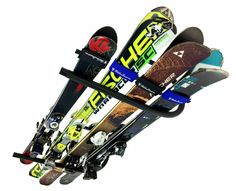 skis and snowboards are hanging from a rack