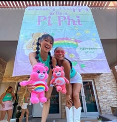 two girls are posing with stuffed animals in front of a sign that says peppui