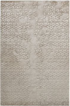 a white rug with an intricate design on the bottom, and a light gray background