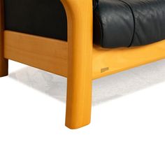 a wooden chair with black leather cushions on it's back end and armrests