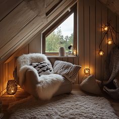 a chair and some pillows in a room with lights on the wall behind it that looks like an attic