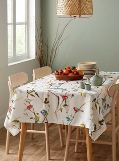 a dining room table set with fruit and plates