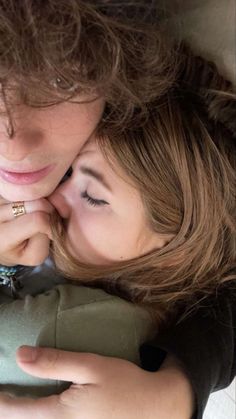 two young women cuddling each other in the middle of a hug, with their eyes closed