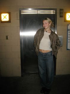 a woman standing in front of an elevator