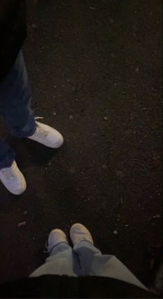 two people standing next to each other with their feet on the ground in front of them