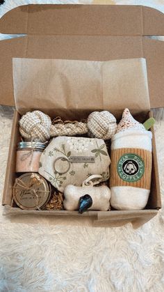 an open cardboard box filled with items on top of a white carpeted floor next to a teddy bear