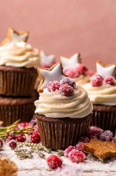 cupcakes with white frosting and stars on top, surrounded by cranberries