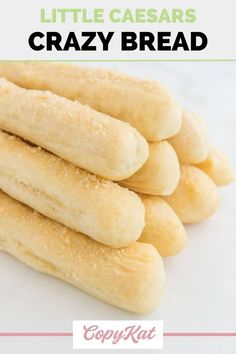 some very tasty looking bread sticks on a white surface with the words, little caesars crazy bread