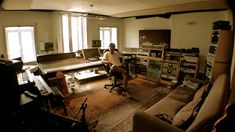 a man sitting in a recording studio surrounded by sound equipment