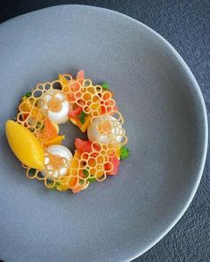 a white plate topped with fruit and veggies on top of a blue table