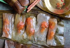 some meat wrapped in plastic sitting on top of a wooden table next to other food items