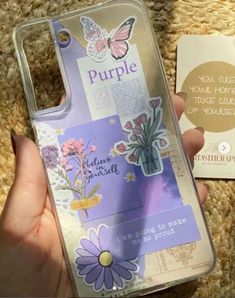 someone is holding up their phone case with flowers and butterflies on the back, which says purple