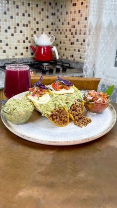 two burritos on a plate with guacamole and salsa