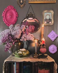 a table with flowers, candles and pictures on the wall