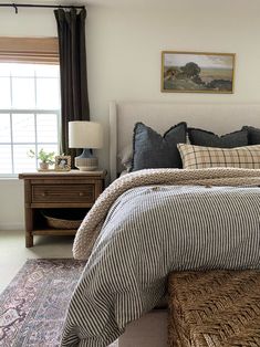 a bedroom with a bed, dresser and window