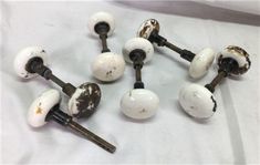 several white knobs and handles with rust on them