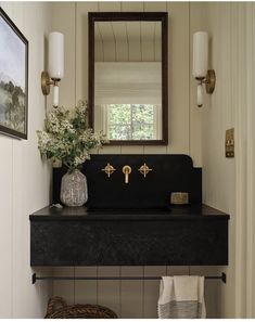 a bathroom sink with a mirror above it and flowers on the counter next to it