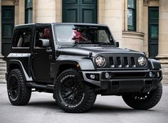 a black jeep parked in front of a building