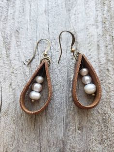 the earrings are made out of leather and have pearls on each tear shaped earring