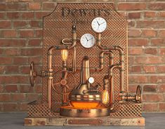 a clock that is on top of a wooden box with pipes and valves in front of a brick wall