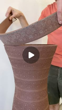 a man is making a vase out of clay