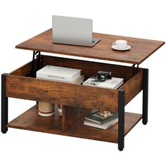 a laptop computer sitting on top of a wooden table next to a coffee cup and saucer