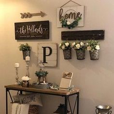 a table with flowers and candles on it in front of a wall that says welcome