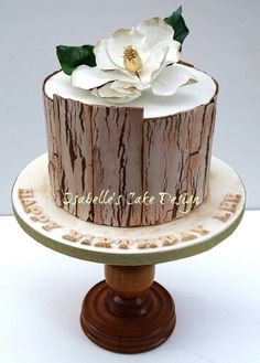 a cake decorated with wood and white flowers