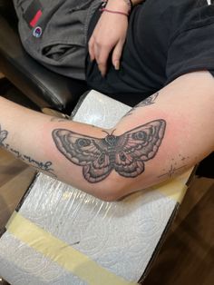 a person with a butterfly tattoo on their arm