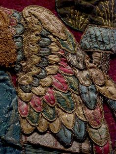 a close up view of an elaborately designed piece of cloth with feathers on it