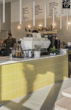 the interior of a restaurant with yellow tiles