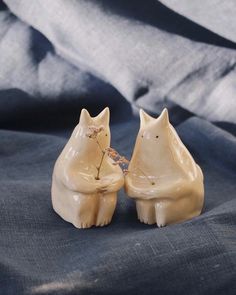 two ceramic cats sitting next to each other