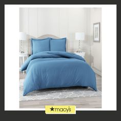 a bed with blue sheets and pillows in a room