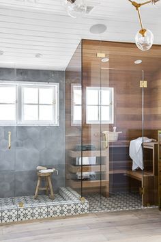 a bathroom with a walk in shower next to a sink and mirror on the wall