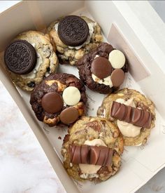 four cookies in a box with oreos and cream fillings on the top one