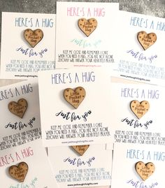 there is a hug wooden heart magnets on top of each other, with the words here's a hug written on them