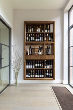 a room filled with lots of bottles of wine on top of shelves next to a window