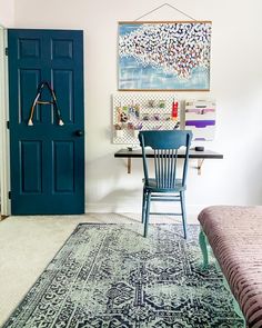 a room with a blue door and a rug on the floor in front of it