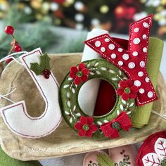 some christmas decorations are sitting on a tray next to a tree and other items in the shape of letters