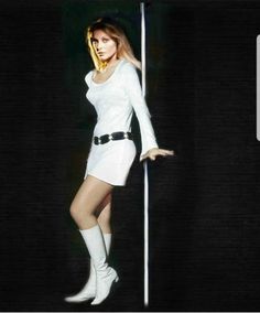 a woman in white is standing next to a pole