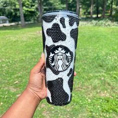 a hand holding up a starbucks cup with black and white polka dots on the bottom