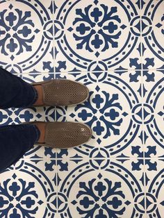 a person standing on top of a blue and white tile floor