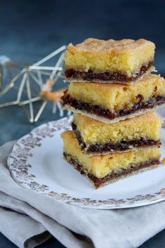 three pieces of cake sitting on top of a white plate next to a sprig of spider web