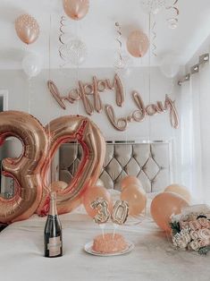 a table topped with balloons and confetti next to a bottle of wine in front of a sign that says happy 30th