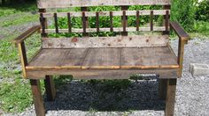 an old wooden bench sitting on top of gravel