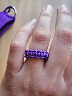 a woman's hand with a purple ring on it