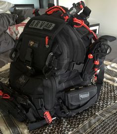 a large black backpack sitting on top of a bed