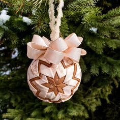 an ornament hanging from a christmas tree with a bow on it's side