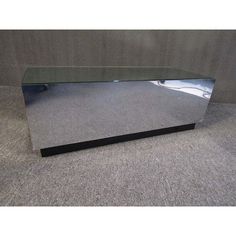 a mirror sitting on top of a carpeted floor next to a gray wall with a black frame