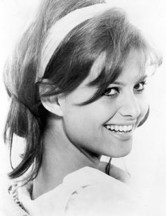 black and white photograph of a woman with her hair in a ponytail smiling at the camera